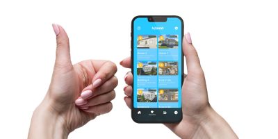 Closeup shot of a woman typing on mobile phone on gray background. Female hands holding a modern smartphone and pointing with figer. Blank screen to put it on your own webpage or message.